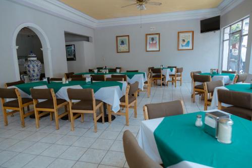 萨卡特卡斯Hotel Zacatecas Courts的用餐室配有绿色的桌椅