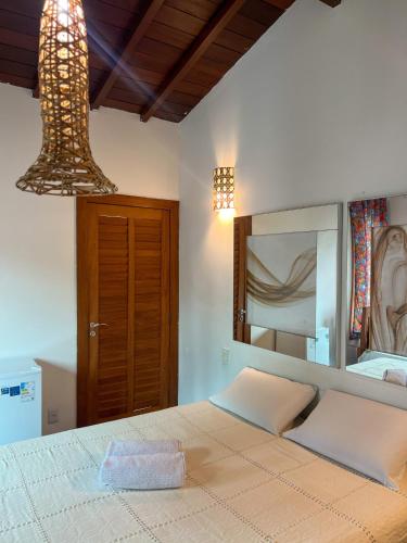 塞古罗港Pousada Casa Mucugê的一间卧室配有一张带大镜子的床