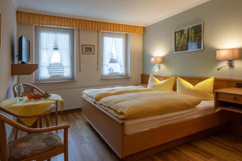 温特贝格波斯特乡村酒店的一间卧室配有一张床、一张书桌和两个窗户。