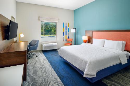 墨尔本墨尔本-维埃拉汉普顿酒店的一间卧室配有一张床、一张书桌和一台电视