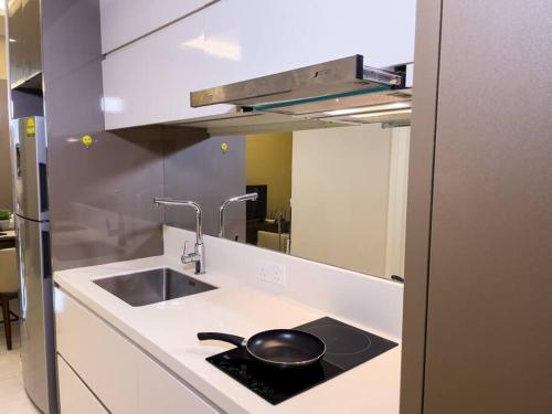 吉隆坡Skypool Couple Suite in Sri Hartamas KL的厨房配有水槽和柜台上的煎锅