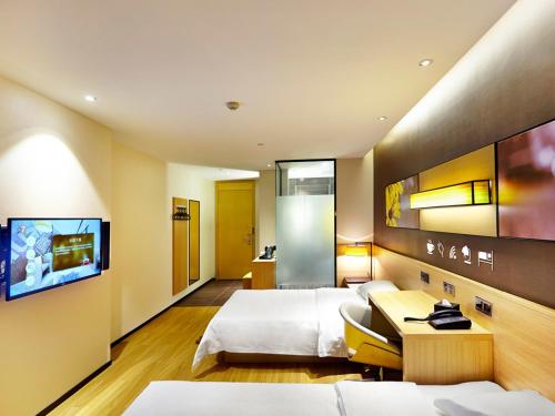 银川7天优品·银川火车站福州南街店的一间酒店客房,设有两张床和电视