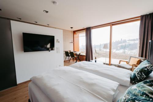 施皮尔费尔德RELAX APARTMENTS Hochgraßnitzberg的卧室设有2张白色的床和大窗户