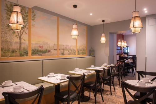 巴黎金太平洋酒店的一间带桌椅的用餐室和一幅画