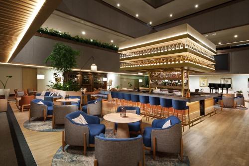 墨西哥城InterContinental Presidente Mexico City, an IHG Hotel的一间设有蓝色桌椅的餐厅和一间酒吧
