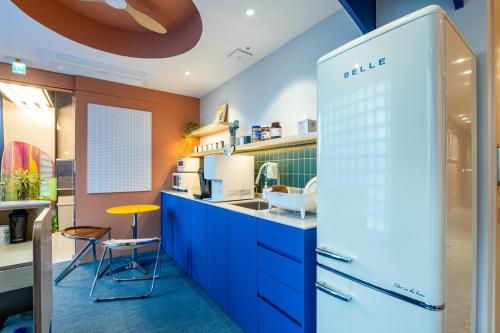 首尔Hithere City Myeongdong的厨房配有蓝色橱柜和黄色凳子