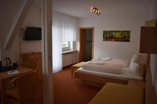 多贝尔Hotel Talblick的一间卧室配有一张床、一张桌子和一台电视