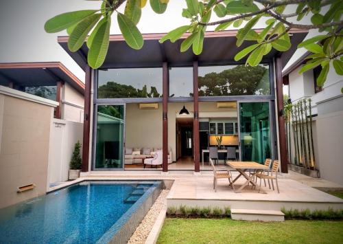 普吉镇Horizon Vista Pool Villa Family Retreat Bangtao的房屋设有游泳池和用餐区