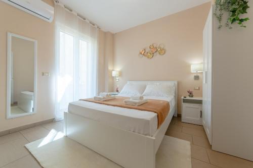 加利波利L'Affaccio Rooms - Lungomare Gallipoli的白色的卧室设有一张大床和一个窗户