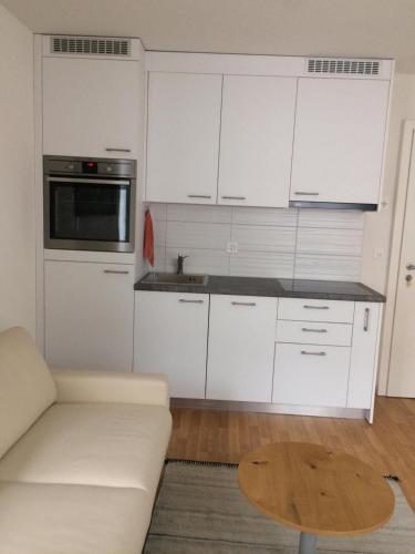 温特图尔2 Zimmer Appartement的厨房配有白色橱柜、沙发和桌子