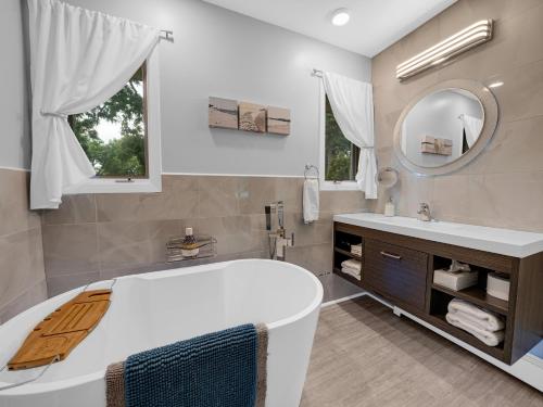 利明顿Coastal Suite - Seacliff Beach Suites的带浴缸、水槽和镜子的浴室