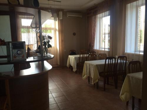 巴甫洛达尔Altyn Adam Hotel的用餐室设有2张桌子和椅子以及窗户。