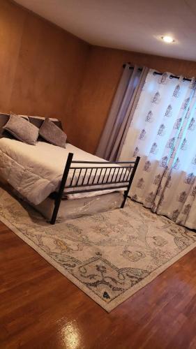 LynnCozy and Sweet home的一间卧室配有一张带地毯的床和窗户