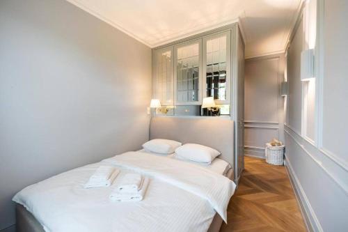 华沙Luxury Garden Apartment的一间小卧室,配有白色的床和两个枕头