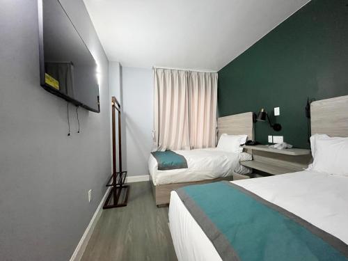 法拉盛Starlight Hotel的酒店客房设有两张床和电视。