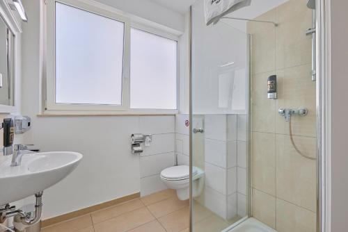 海德堡伯丁海德堡酒店的浴室配有卫生间、盥洗盆和淋浴。