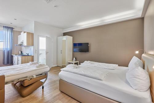 海德堡伯丁海德堡酒店的一间带白色大床的卧室和一间厨房