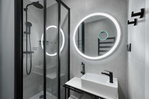热舒夫Best Western Plus Hotel Rzeszow City Center的浴室配有盥洗盆和带镜子的淋浴