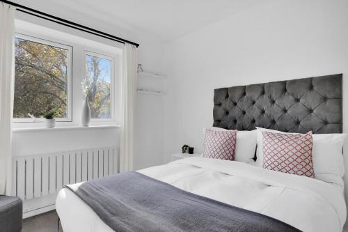 伦敦Peckham apartments by APS的白色的卧室设有床和窗户
