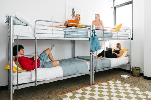 堪培拉The Village Hostels Canberra的一组坐在双层床上的人