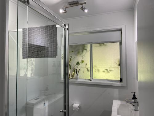 ManyanaConjola Inn-let - Self Contained Unit - Lake Conjola的带淋浴和卫生间的浴室以及窗户。