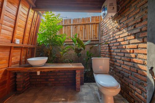 吉安雅Kubu Selat Villa and Glamping的一间带卫生间和砖墙的浴室