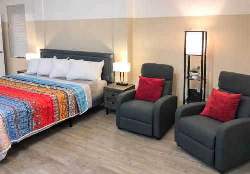 迈尔斯堡Star Apartments的一间卧室配有一张床和两把椅子