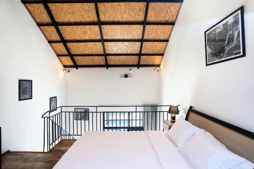 坎古ND LOFT 2 by Kasta Hospitality的一间卧室设有一张床和木制天花板