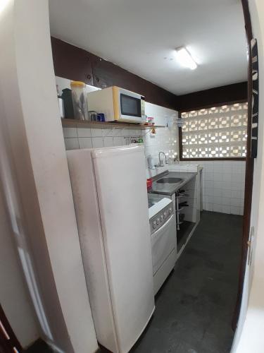 卡拉瓜塔图巴Chalés Recanto da Praia的小厨房配有冰箱和微波炉。
