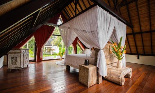 KrambitanAnima Retreat Bali的一间卧室,卧室内配有一张天蓬床