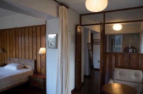BurhānilkanthaInitial Cold Lodge的卧室配有1张床、1张桌子和1把椅子