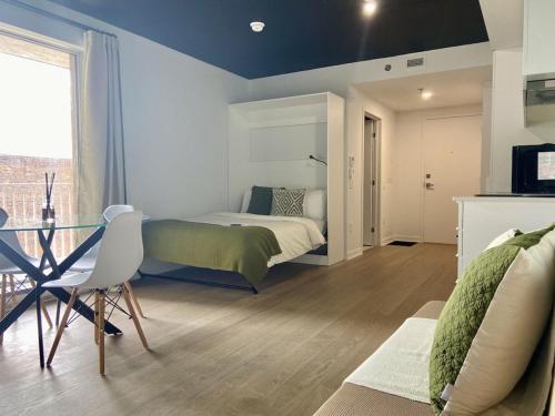 蒙特利尔Appartement condo avec terrasse privée dans le Quartier des Spectacles的一间卧室配有一张床、一张桌子和一张沙发
