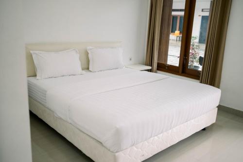 怀卡布巴克Morika Inn的卧室内的白色床和白色枕头