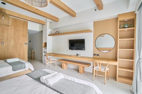纳苏格布Yugen Suites 208 at Pico De Loro的一间卧室配有两张床、一张桌子和一面镜子