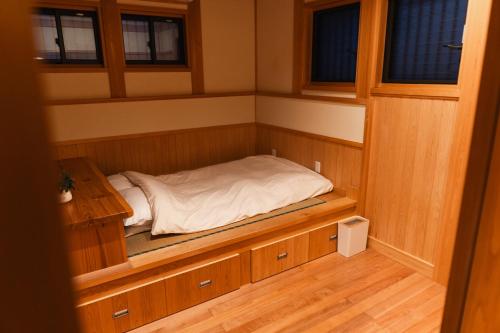 熊本合い宿 くまもと的一间小型客房,设有一张位于桑拿浴室内的床铺
