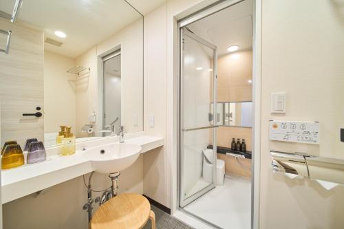大阪Via Inn Abeno Tennoji的白色的浴室设有水槽和淋浴。