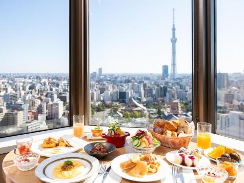 东京浅草豪景酒店的窗前带食物盘的桌子