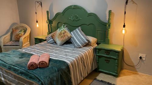 布隆方丹Le Petit Guesthouse的一间卧室配有绿床和毛巾