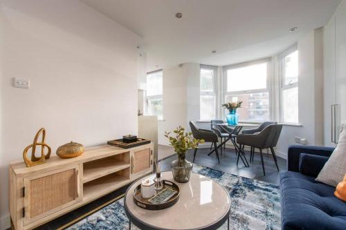 伦敦Elevated Elegance: 1BR 1BA Flat in Wellmeadow Rd的客厅配有蓝色的沙发和桌子