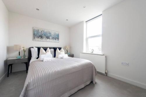 伦敦Elevated Elegance: 1BR 1BA Flat in Wellmeadow Rd的白色的卧室设有一张大床和一个窗户