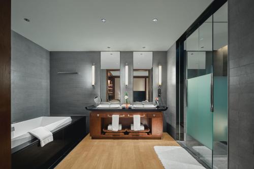 苏州苏州托尼洛兰博基尼书苑酒店的浴室配有两个盥洗盆和浴缸。