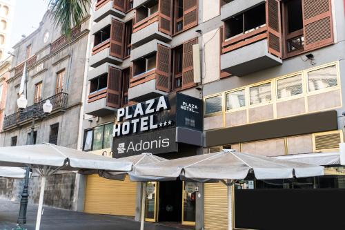 圣克鲁斯-德特内里费阿多尼斯广场酒店的大楼前有遮阳伞的酒店