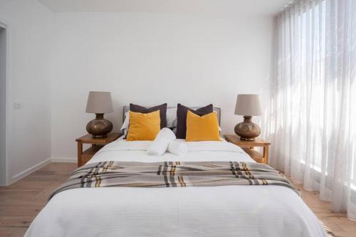 墨尔本Richmond Sanctuary的一间卧室配有一张带黄色枕头的大床