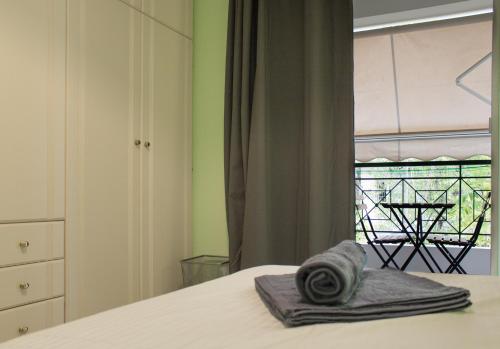 雅典Gtrip Ellinikon Experience Apartment - 31506的一间卧室配有一张床,窗户配有桌子