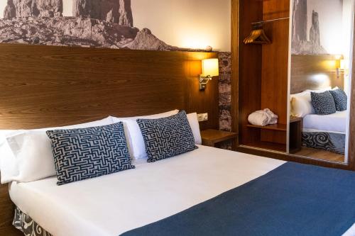 圣克鲁斯-德特内里费阿多尼斯广场酒店的一间卧室配有一张带蓝色和白色枕头的床