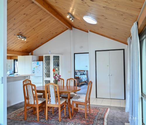 奥克兰Sunny Beachview Homestay Auckland的一间厨房和带木制天花板的用餐室