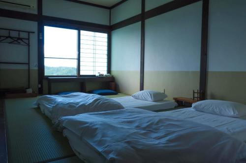 与谢野町Kaya Yamanoie的带2扇窗户的客房内的3张床