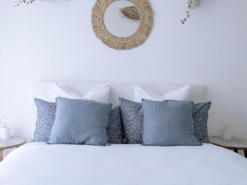 贝肯里德Chez-Marie Vue fantastique entre lac et montagne的一间卧室配有一张白色的床、蓝色枕头和镜子