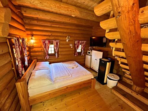 普列维扎Ubytovanie Koliba Pacho - Zrub Zuzka的小木屋内一间卧室,配有一张床