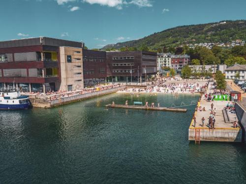 卑尔根Byleilighet i sjøkanten m terrasse的一群人站在水体上的码头上